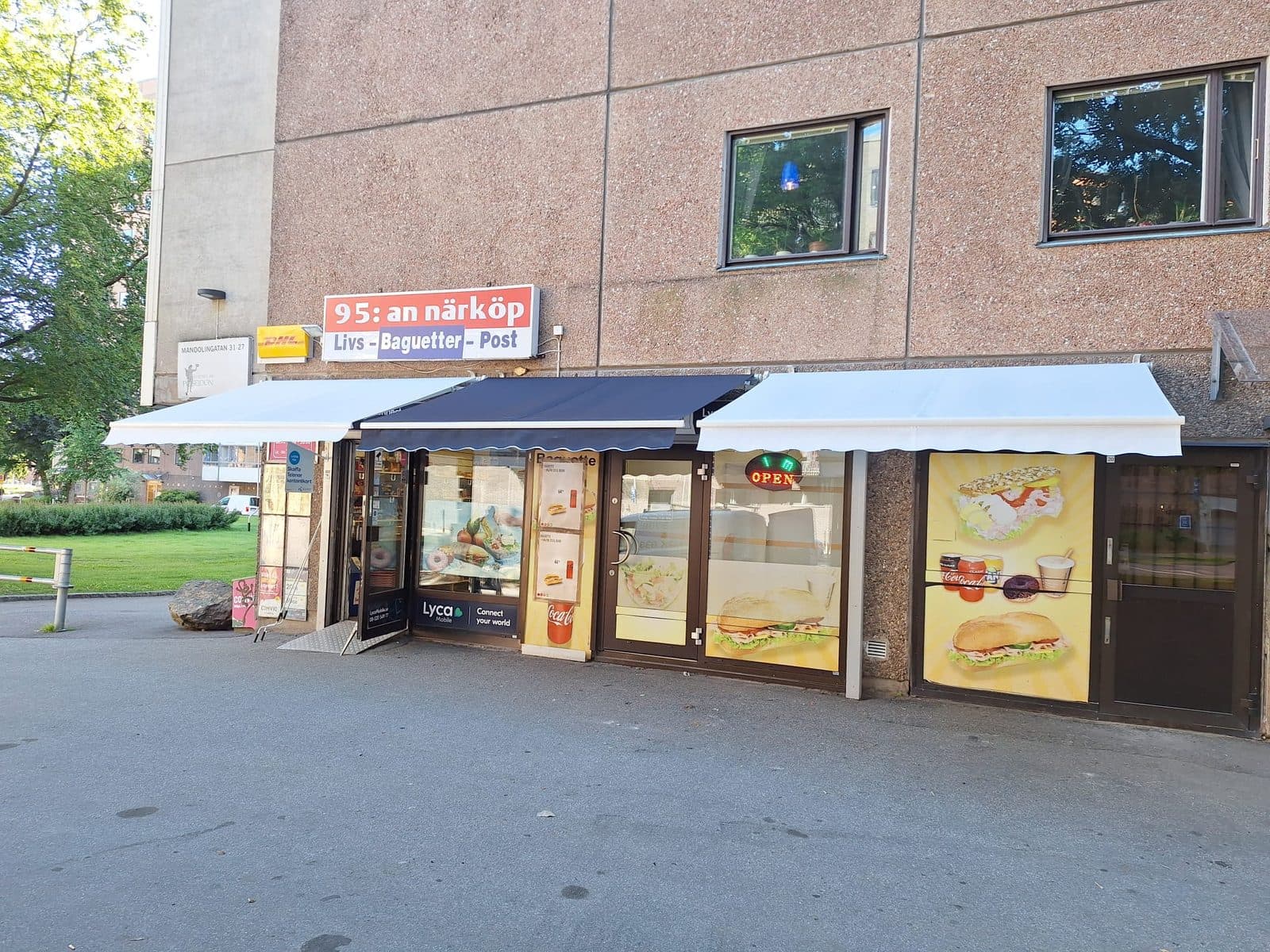 Färdig butiksfasad med nya markiser uppsatta ovanför entrén och skyltfönstren