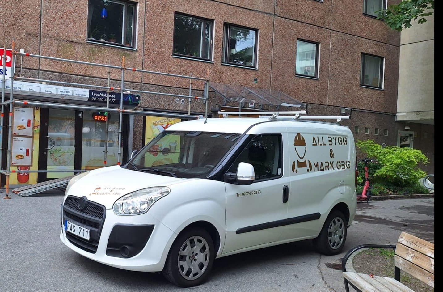 Firmabilen från All Bygg & Mark parkerad framför butiken med ställningen uppe