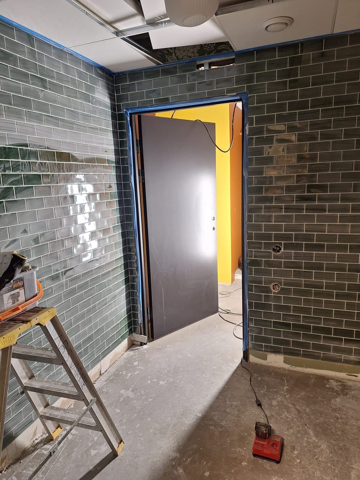 Samma toalett under kaklingen, med maskerad dörrkarm och betonggolv
